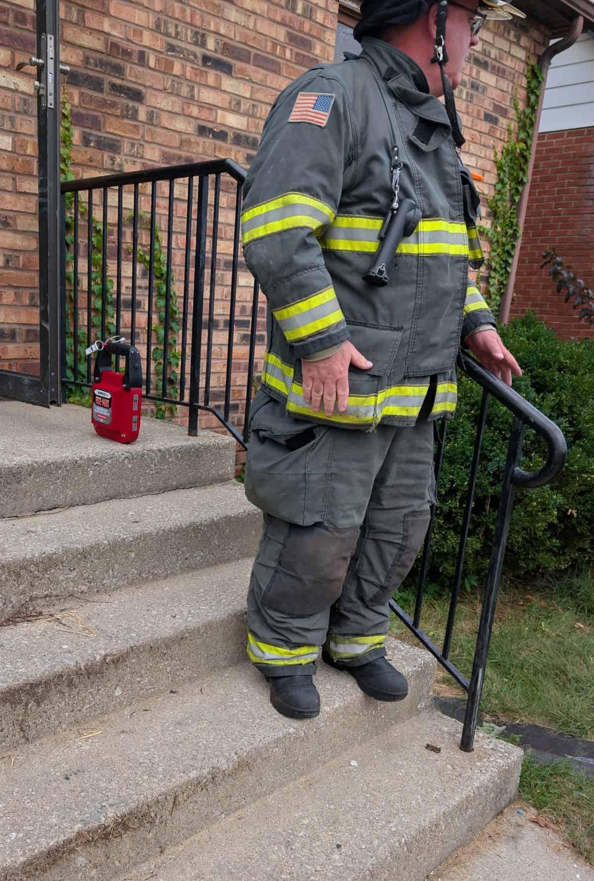 Firefighter on the front steps with the FS2-MAX on the stoop behind him